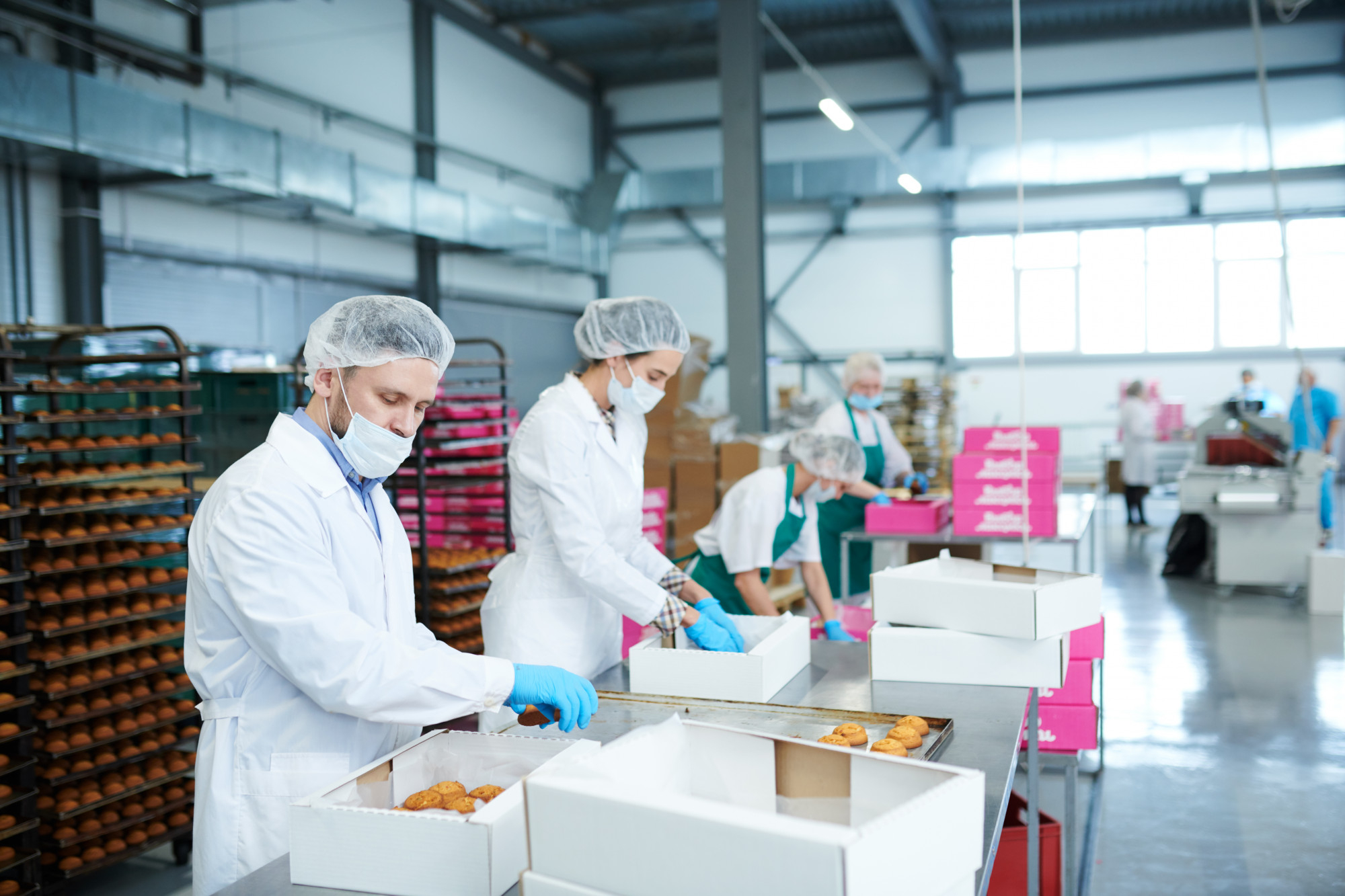 confectionery-factory-employees-putting-pastry-into-boxes